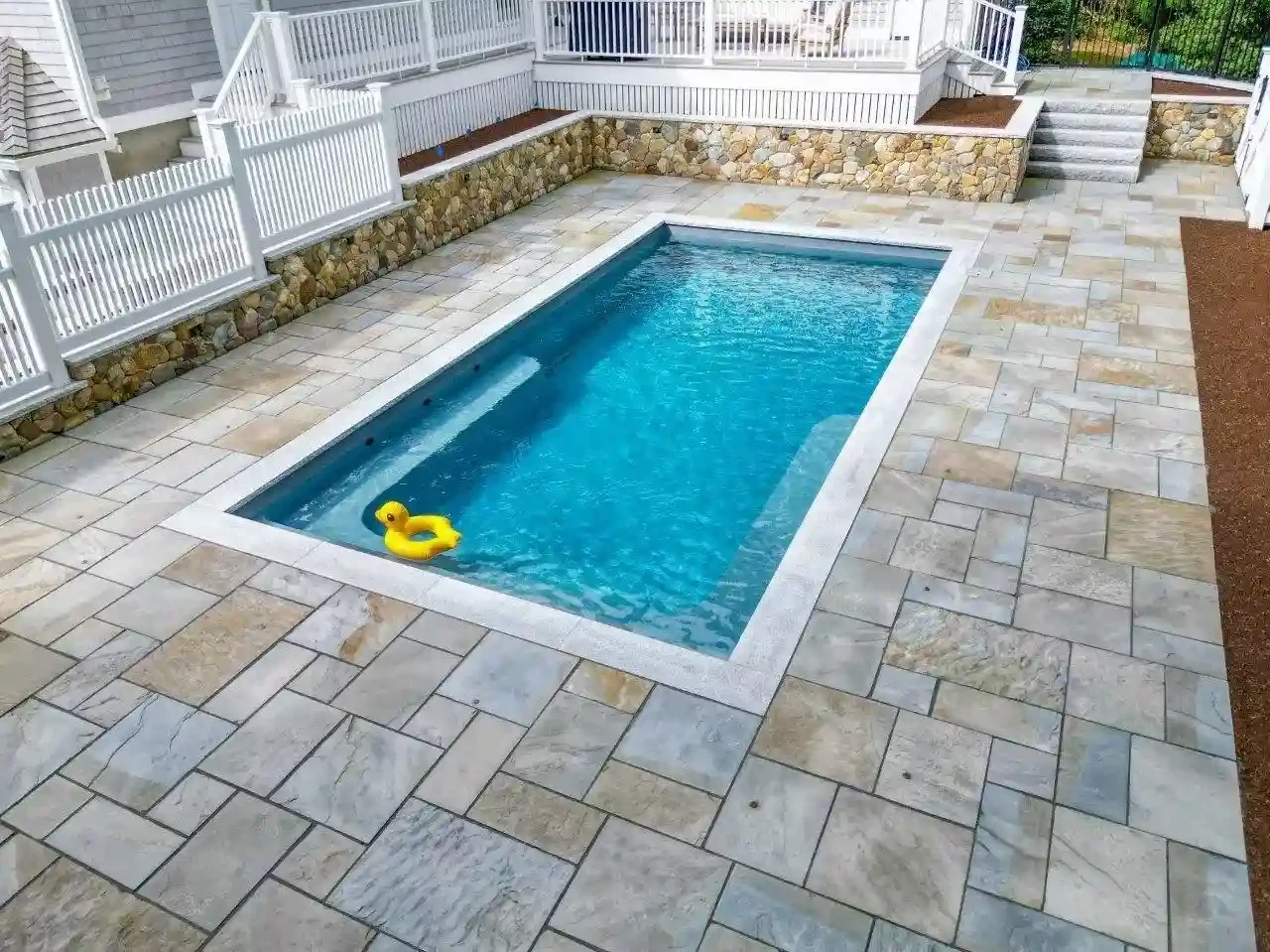 Round-stone retaining wall and steps detail beside the pool patio