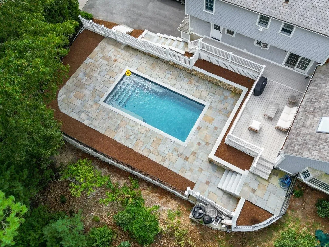 Aerial view of the pool patio connecting to the home's deck and lounge area