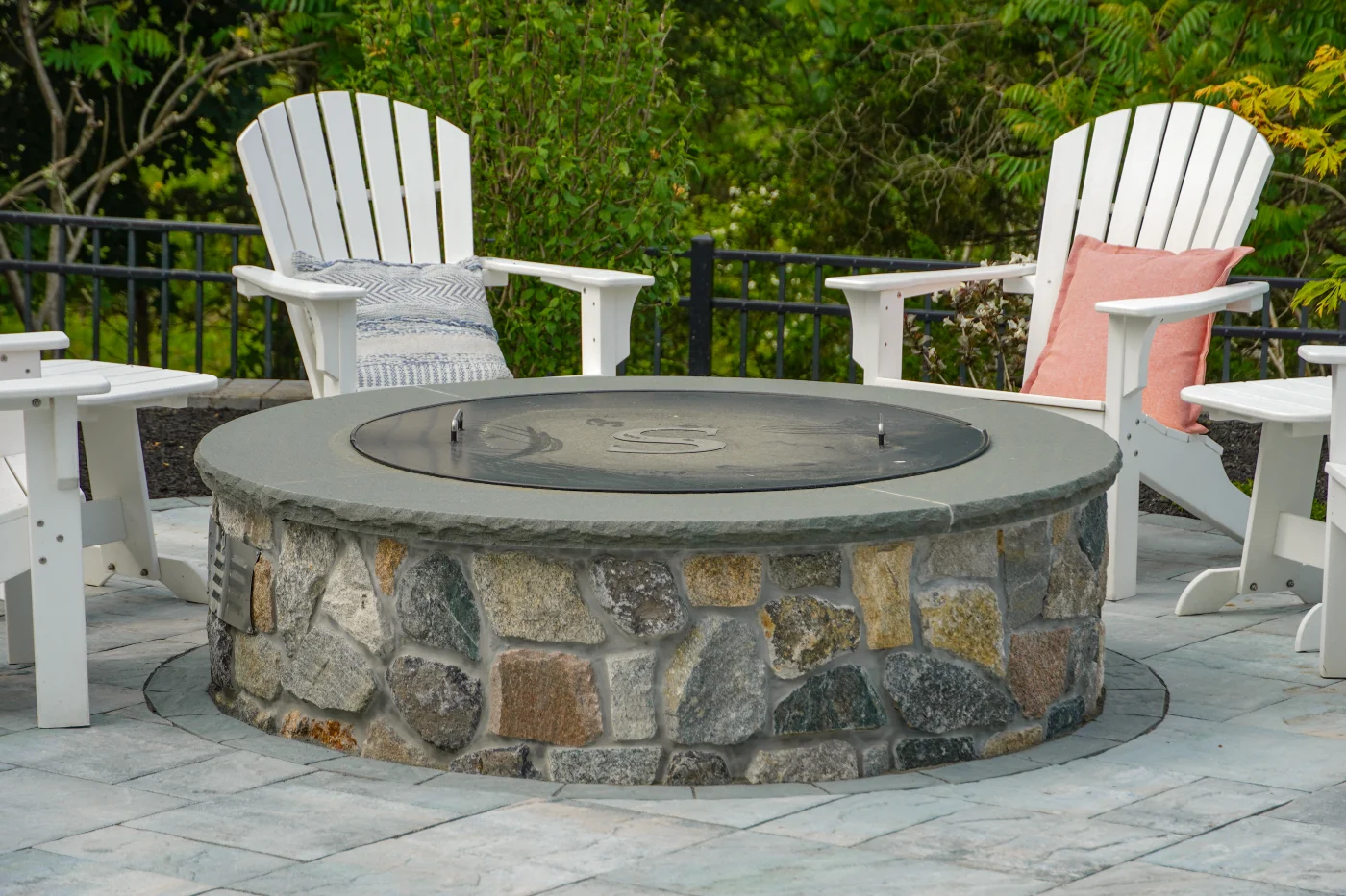 Stone fire pit with Adirondack chair seating